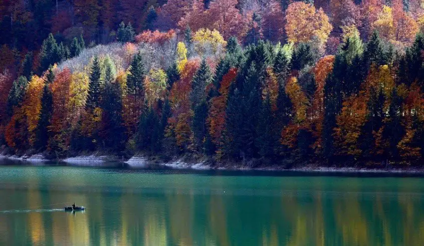 The fisherman sails on the Sylvenstein lake in Bavaria, Germany