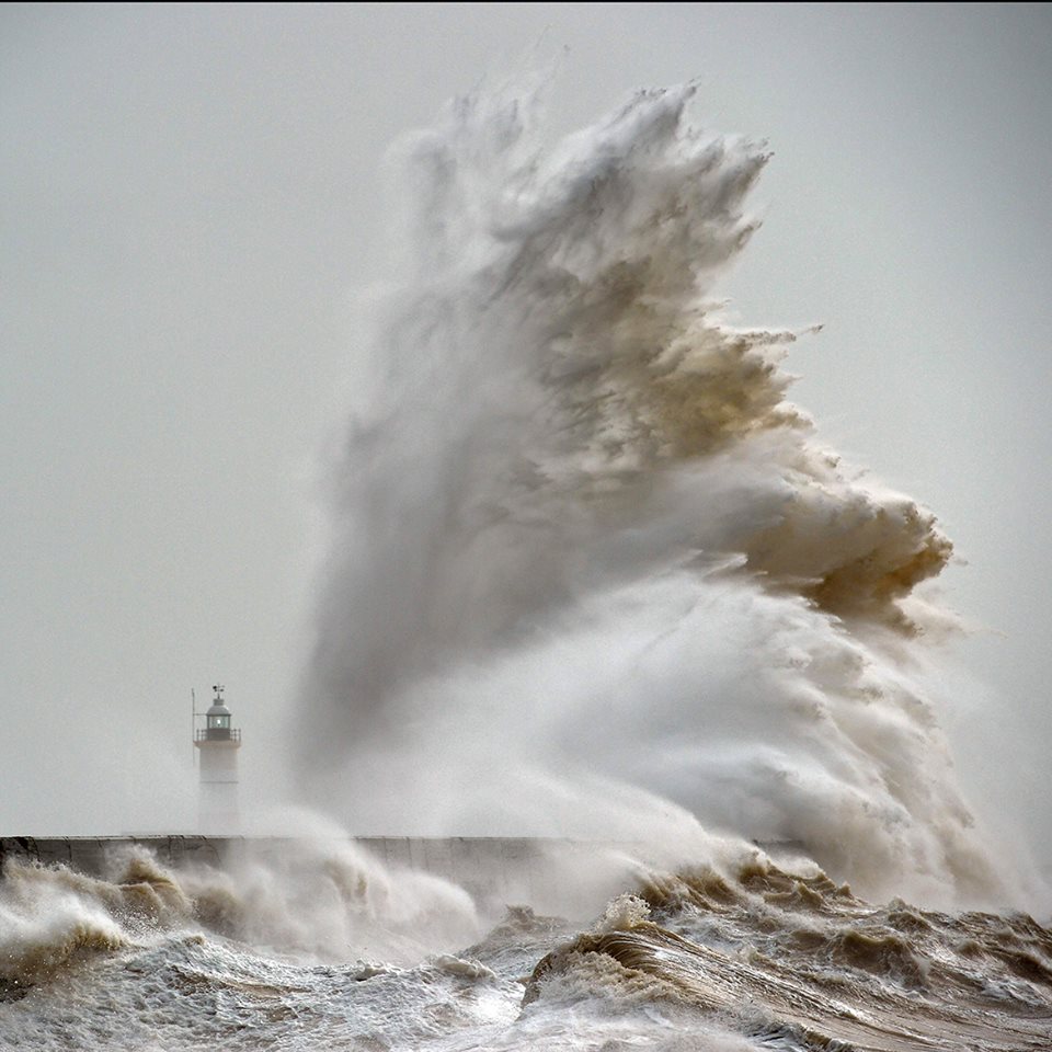 A huge wave by the lighthouse