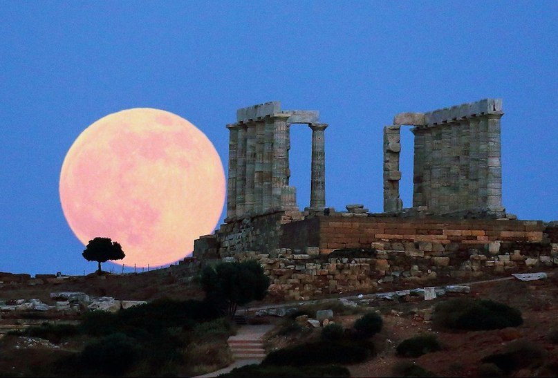 Полная луна восходит над руинами храма Посейдона, мыс Сунион, Греция.