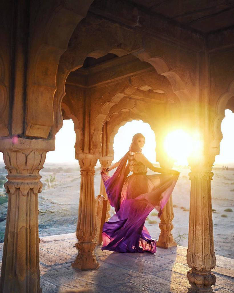 A girl travels the world in wonderful dresses and takes a photo in the most beautiful places