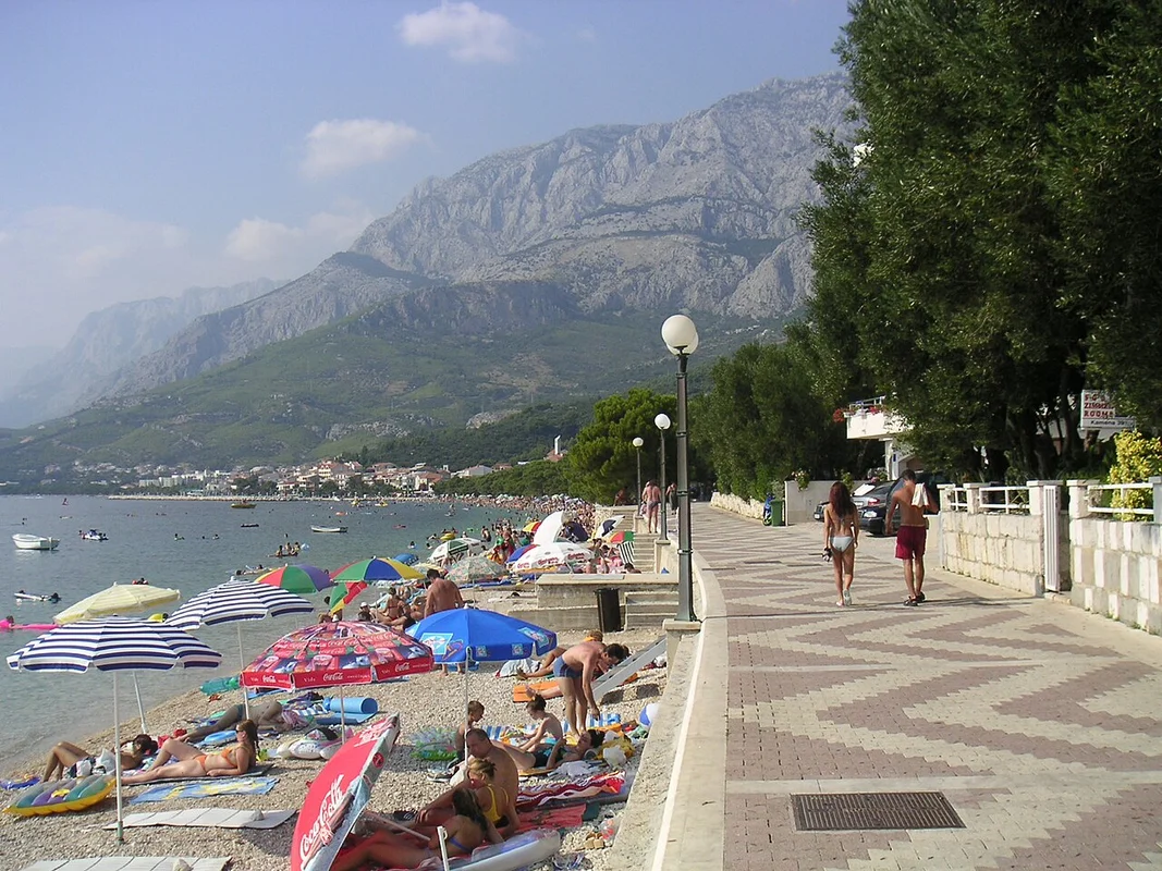 Panoramic view of Makarska Bay, with a gravel beach and the Biokovo mountains in the background