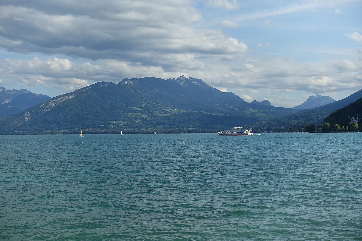 Schloss Annecy mit runden Türmen und steinernen Mauern vor dem Hintergrund des Sees