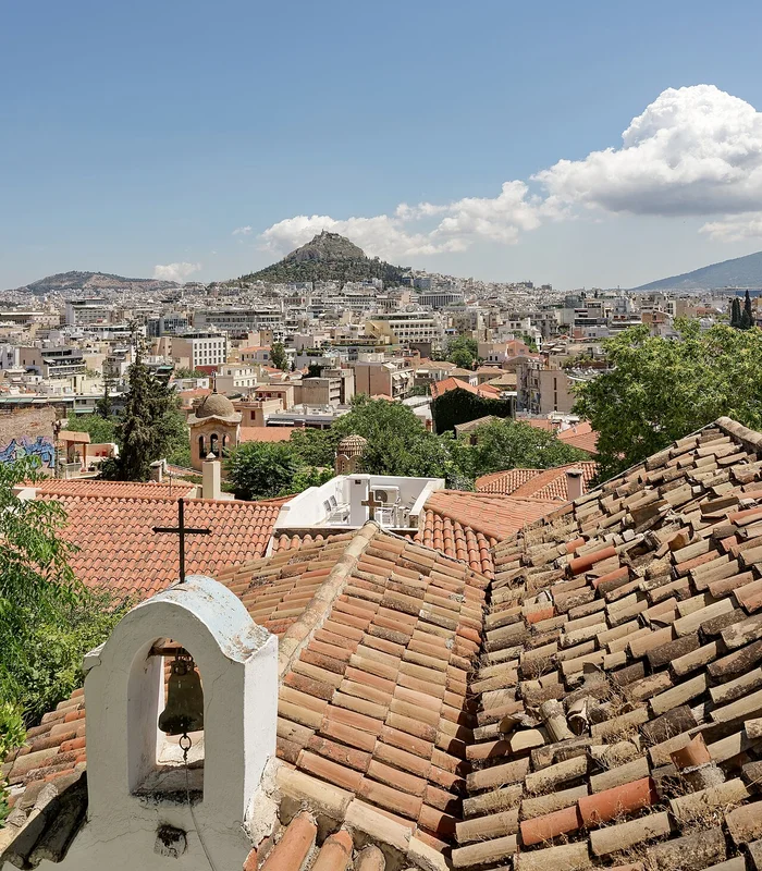 Узкая улочка Анафиотики с белёными стенами и цветочными горшками