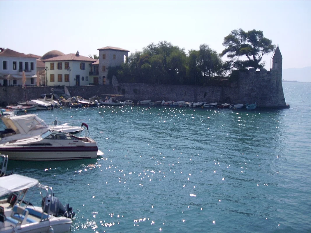 Круглый старый порт Нафпакта с рыбацкими лодками и крепостными стенами