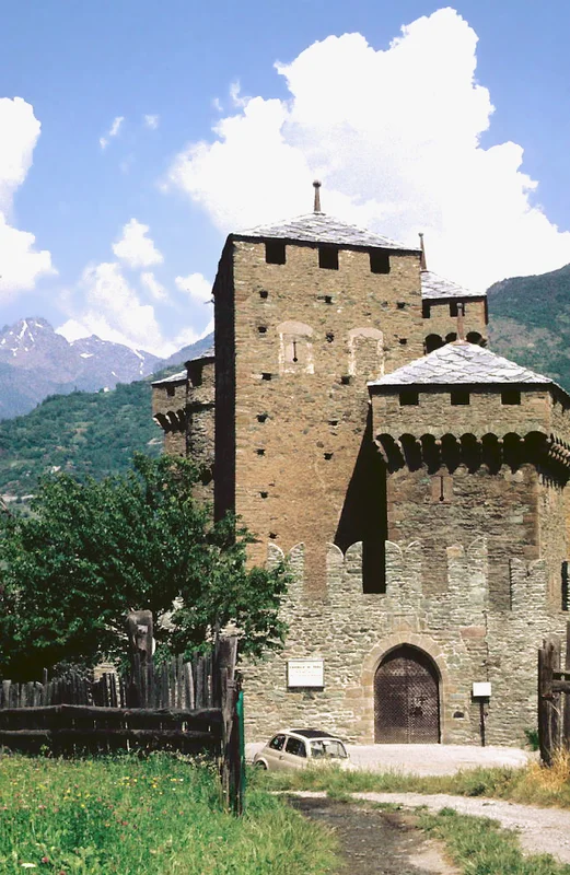 Zamek Fénis z charakterystycznymi wieżami i podwójnymi murami; wewnętrzny dziedziniec ma średniowieczną architekturę