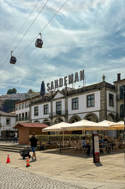 Гид в чёрном плаще Sandeman проводит тур по погребу